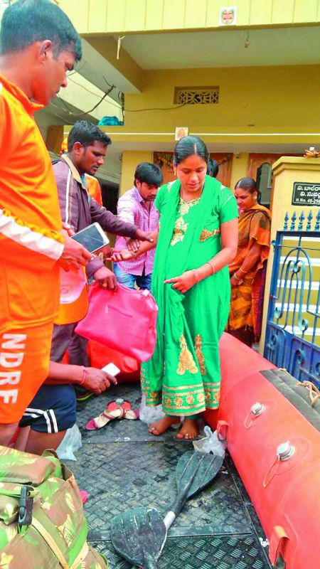A pregnant woman from the NMDC colony in East Anandhbagh is helped onto the service boat of the NDRF on Thursday.  (Photo: DC)