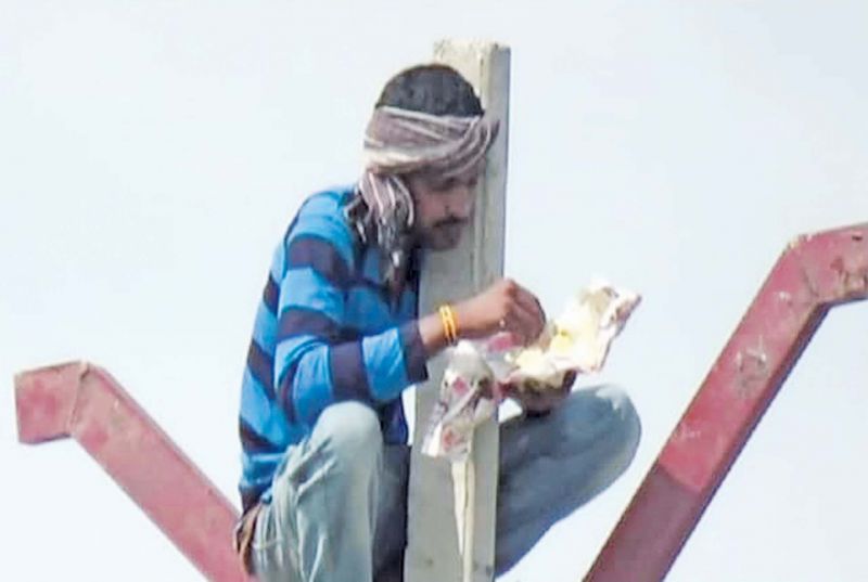 A worker having his food atop an EB pole.