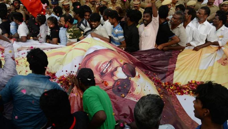 Supporters carry a large banner of the DMK patriarch during the funeral procession in Chennai. (Photo: AFP)