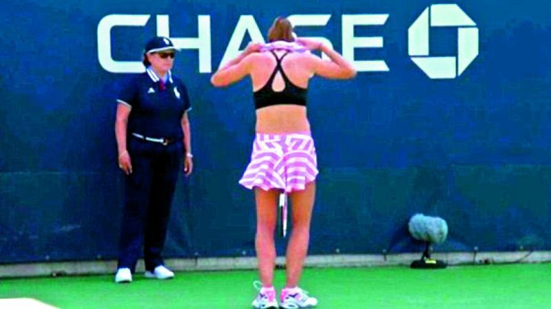 Cornet changing her t-shirt at the back of the court after  wearing it inside-out by mistake.