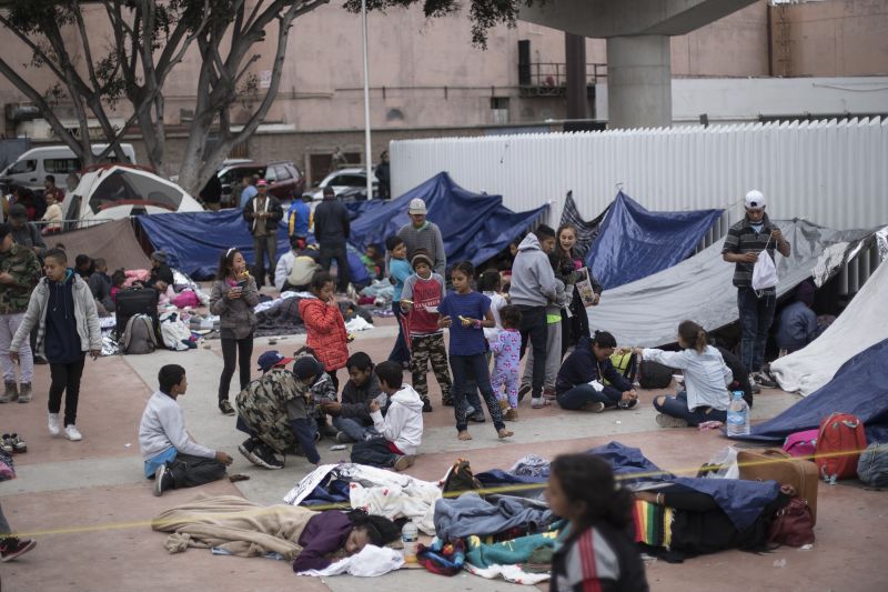 In this Monday, April 30, 2018 file photo, Migrants wait for access to request asylum in the U.S., at the El Chaparral port of Entry in Tijuana, Mexico, Top officials from the U.S. and Mexico will begin talks Monday, June 3, 2019 in a scramble to fend off President Donald Trump s threat of devastating tariffs and meet his demand for fewer migrants at the border. (AP Photo/Hans-Maximo Musielik, File) 
