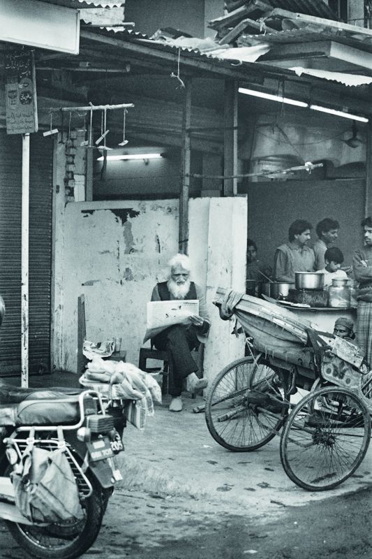 Husain reading the newspaper in Old Delhi.
