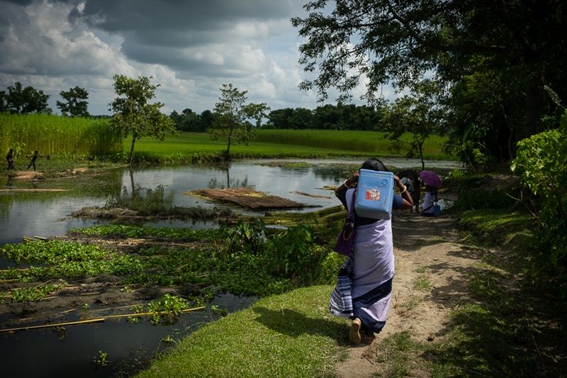 The ASHA workers continue without a break, wading through waterbodies and shifting the weight of the vaccine carriers from one shoulder to another. (Photo: MoHFW)