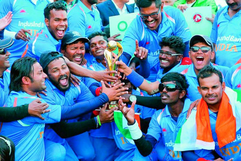 The visually impaired Indian cricket team celebrating their victory with the cup.