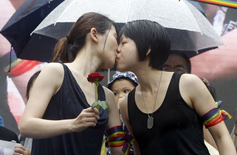 Same-sex marriage supporters kiss outside the Legislative Yuan Friday, May 17, 2019, in Taipei, Taiwan after the legislature passed a law allowing same-sex marriage in a first for Asia. The vote Friday allows same-sex couples full legal marriage rights, including in areas such as taxes, insurance and child custody. (AP Photo/Chiang Ying-ying)