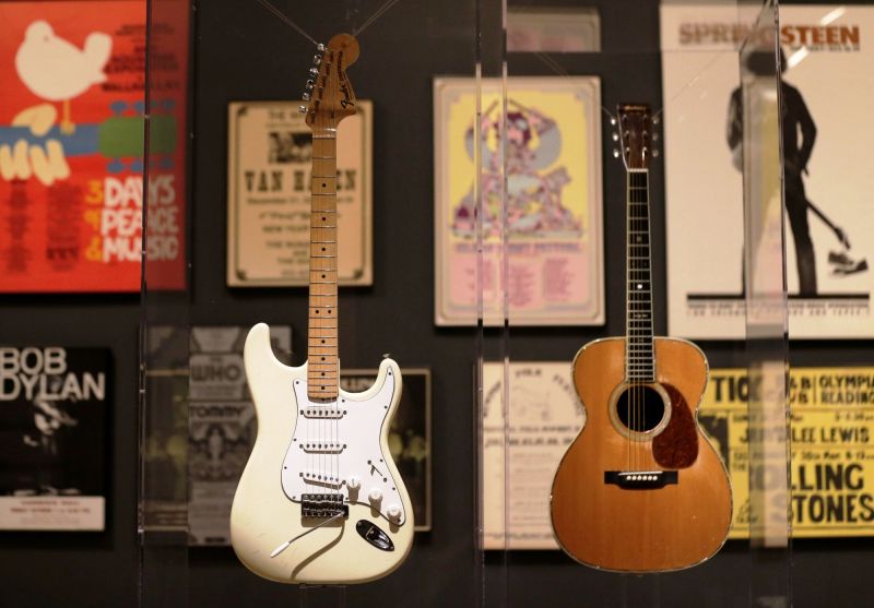 Guitars used by Jimi Hendrix (L) and Eric Clapton are displayed with concert posters at the exhibit. (Photo: AP)