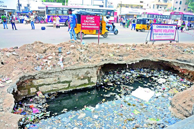 A portion of the road which caved some time ago due to ongoing Metro Rail works. The open hole was not repaired and is now filled with water and garbage causing risk to pedestrian passing by.  (Photo:DC) 
