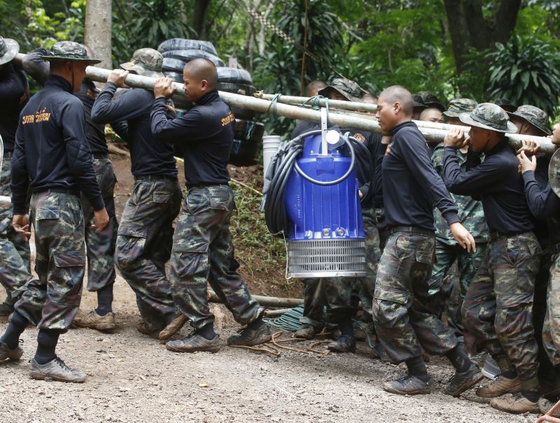 Soldiers carry a pump to help drain the rising flood water. (Photo: AP)