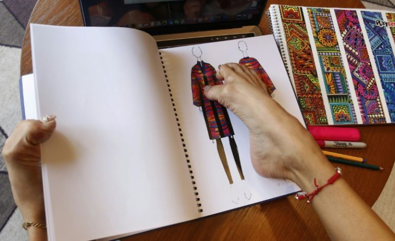 Adriana drawing her fashion collection