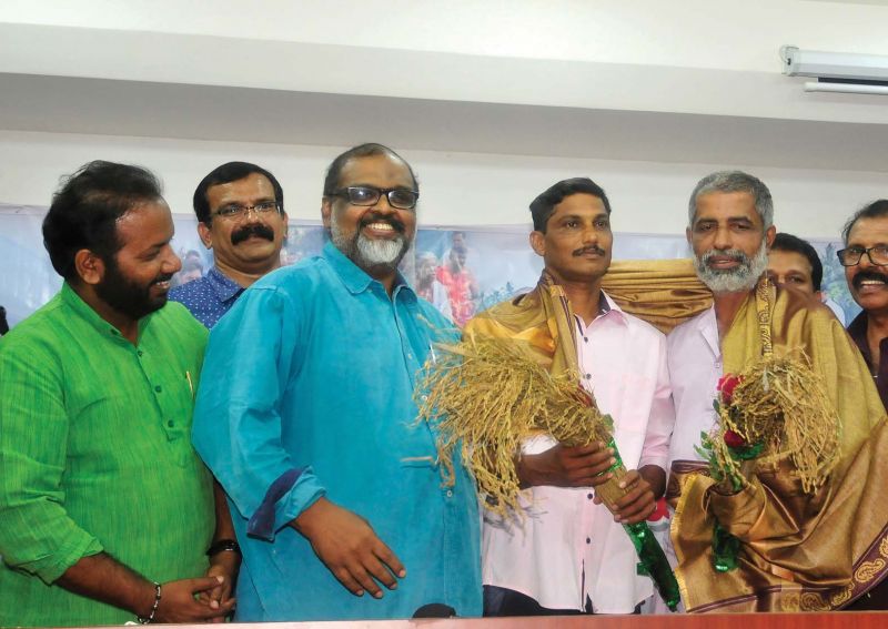 CMP leader C.P. John welcomes Keezhattoor agitation leaders Suresh and Manoharan with paddy stalks by  in Thiruvananthapuram on Saturday.  (Photo:  A.V. MUZAFAR)