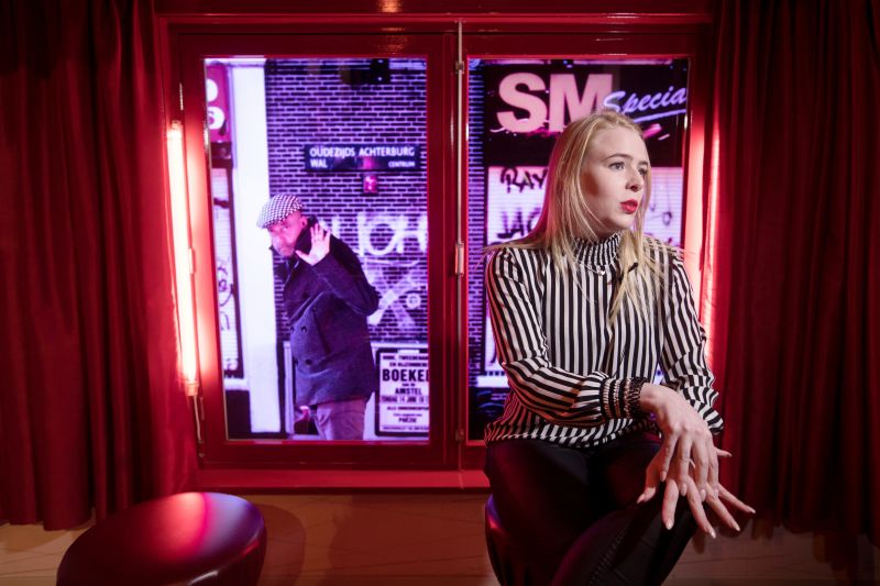 Museum manager Natascha Flipsen of the Red Light Secrets Museum of Prostitution, interviewed in front of a video projection portraying people passing the window of a sex worker in Amsterdam's red light district. (Photo: AP)