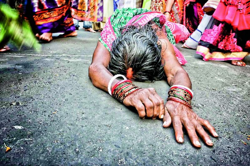 A woman takes part in the festival of Dondi that takes place during the summer. The devotees take a dip in the holy Ganges at Kalighat and go to the temple on hands and knees.