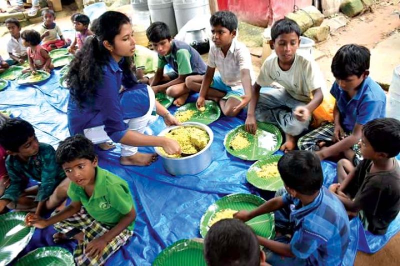 Kinnera Mannava serving food to the kids at a slum area