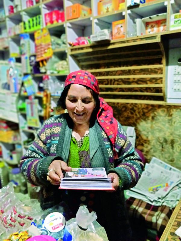 A woman in Jibhi, Himachal showing memories of her life from a photo album