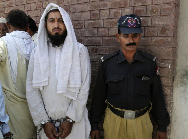 A handcuffed Pakistani cleric who allegedly raped a child, stands outside a court in Kehror Pakka, Pakistan on May 4. (Photo: AP)