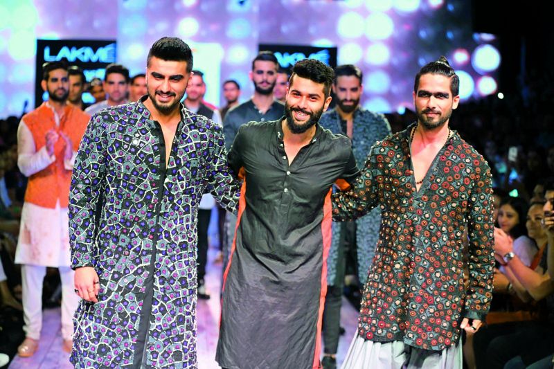 Designer Kunal Rawal dressed Shahid Kapoor and Arjun Kapoor in blingy clothes and heavy makeup for one of his shows at Lakme Fashion Week.