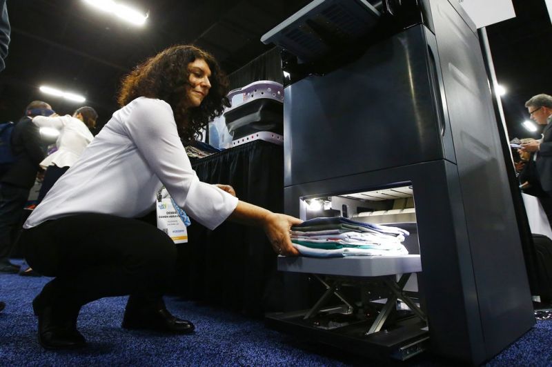 Debbie Cohen-Abravanel, CMO at Foldimate, demonstrates the new device that folds your clothes automatically, at the CES Unveiled at CES International, Sunday, Jan. 6, 2019, in Las Vegas. (AP Photo/Ross D. Franklin)