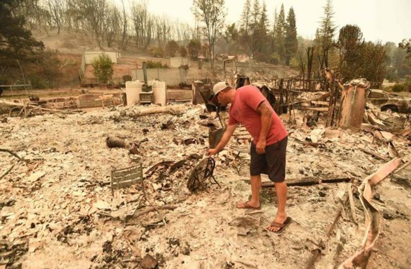 A person looks at what remains of his burned home during the Carr fire in Redding, California on July 27. (Photo: AFP)