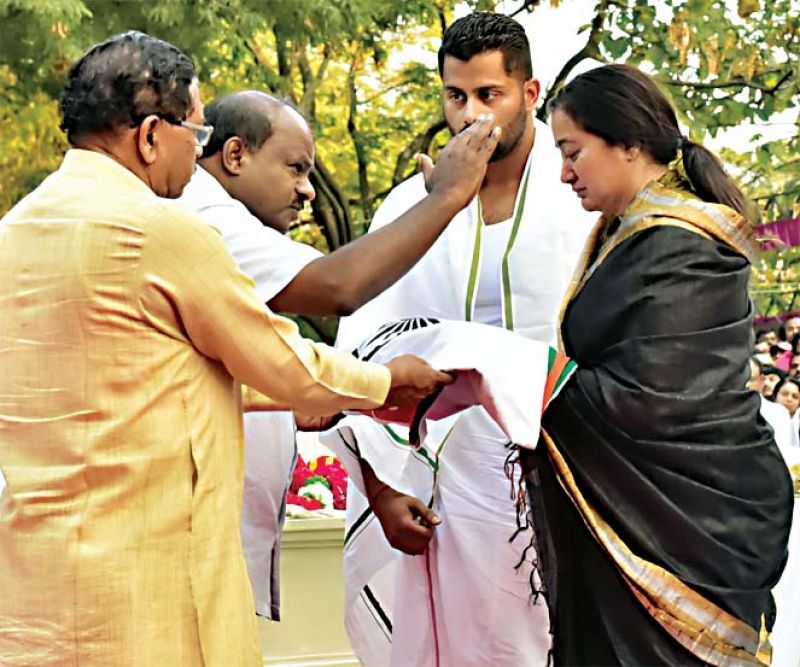The CM and Deputy CM hand over the tricolour which was draped on Ambareesh's body to his wife Sumalatha and son Abhishek.