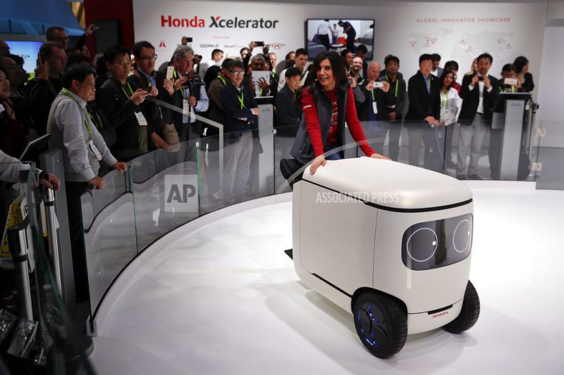 An exhibitor demonstrates the Honda robotics concept 3E-C18.