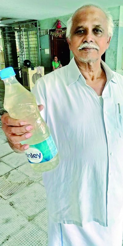 Resident Mohan Rao shows a bottle of contaminated water.
