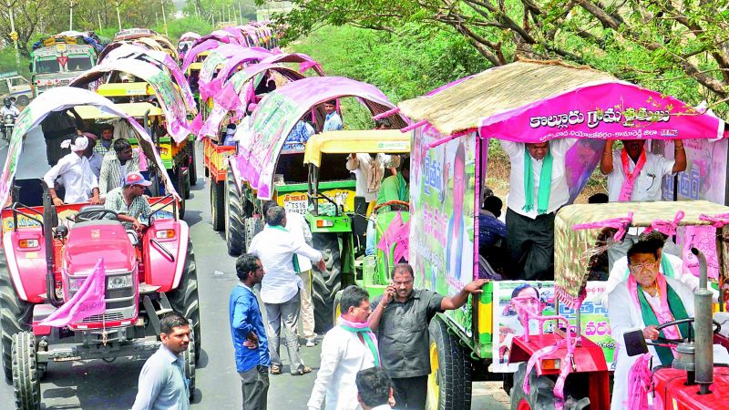 TRS leaders and workers reach the public meeting venue in tractors decorated in party colours on Thursday. (Photo: Deccan chronicle)