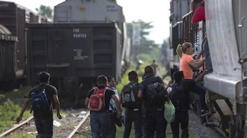 Immigrants run to jump on a train during their journey toward the US-Mexico border (Photo: AP)
