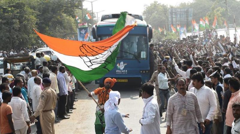 A Congress supporter waves party flag at Prantij town, some 65 kms from Ahmedabad on November 11, 2017. (Photo: AFP)
