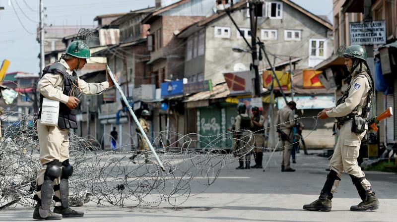 Security jawans setting a temporary barricade of razor wire during restrictions in Srinagar on Thursday. Authorities imposed curfew and restrictions in many parts of Valley to maintain law and order. (Photo: PTI)