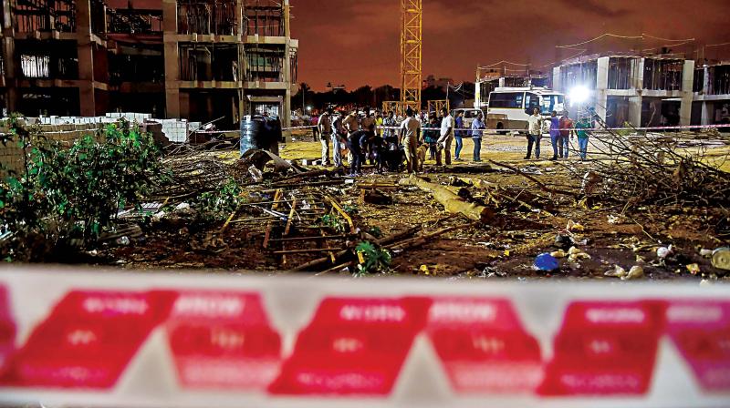 Bomb disposal squad members and police officers inspect the blast site at HAL quarters construction site, in Bengaluru on Tuesday (Photo: PTI)