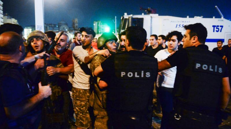 Turkish soldiers, arrested by civilians, are handed to police officers, in Istanbuls Taksim square. (Photo: AP)