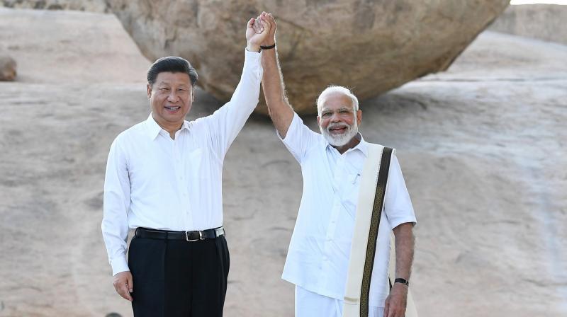 Chinese President Xi Jinping and Indian Prime Minister Narendra Modi raise hands together at Arjunas Penance in Mamallapuram, India. (Photo: AP)