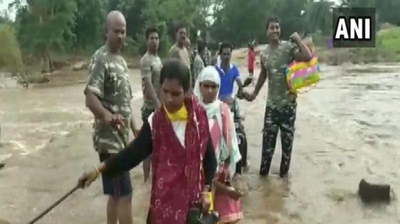 Human chain formed by CRPF jawans to help local cross flooded bridge