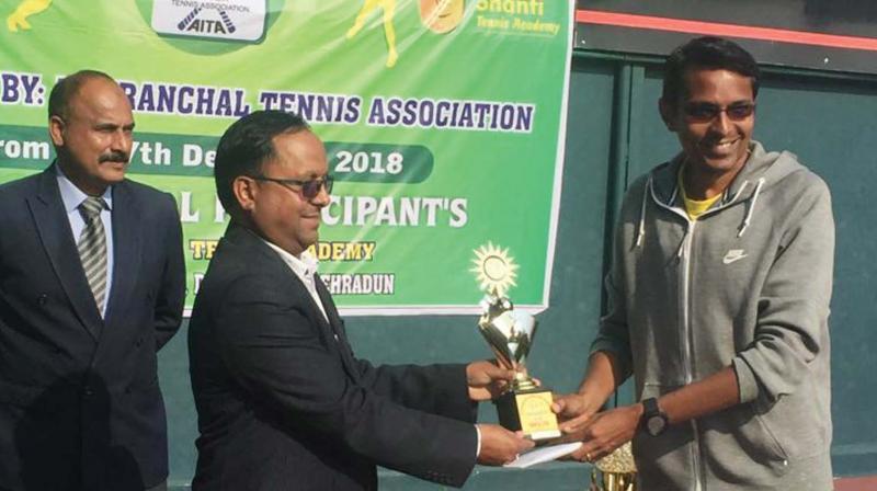 M.S. Krishnakumar (right) receiving the champions trophy in the singles category of a World Ranking Seniors Tennis Tournament held in Dehradun. Krishnakumar, who is an assistant section officer of the Government Secretariat, was also the runner-up in the doubles category.