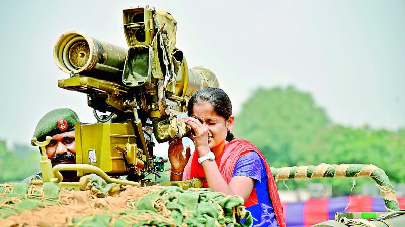A girl looks through the scope of an army missile launcher after the Army displayed its tanks and weapons used during war at Parade Grounds on Saturday. (Photo: DC)