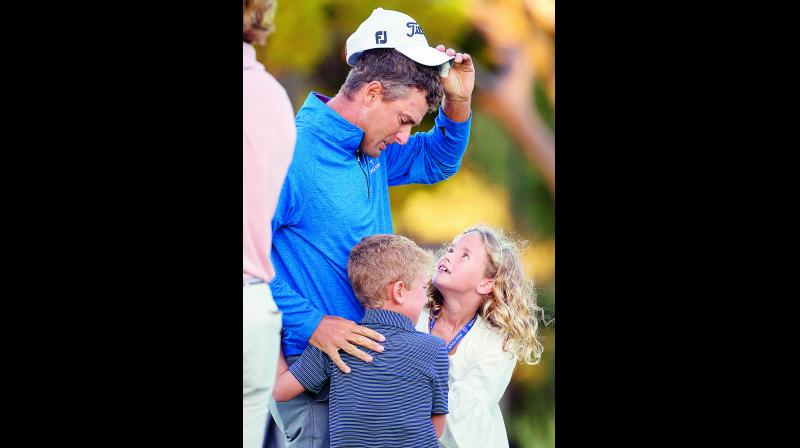 Charles Howell looks at his children Charles and Ashley after winning the final round of the RSM Classic golf tournament on Sunday. (Photo:  AP)