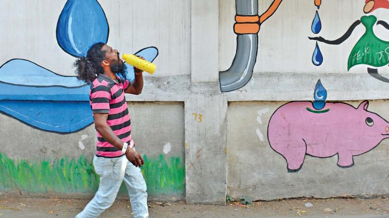 The wall painting lays stress on water conservation as a man drinks water while walking in Purasawalkam. (Photo: DC)