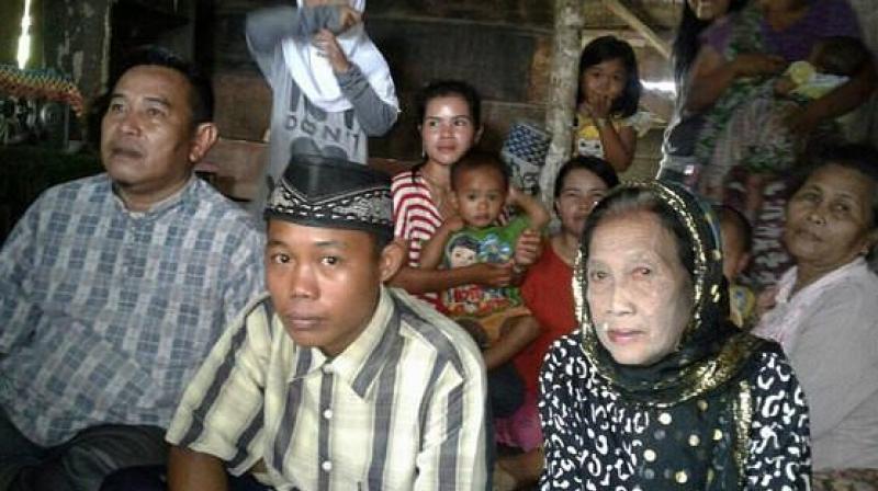 This undated recent photograph shows 73-year-old Rohaya binti Kiagus Muhammad Jakfar (front 2nd R) sitting with her 15-year-old teenage husband Selamet Riyadi (front 2nd L) in Baturaja, South Sumatra province. (Photo: AFP)
