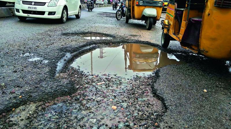 Drivers try to avoid the huge potholes on a road in Sainikpuri following the recent rains. (Photo: DC)