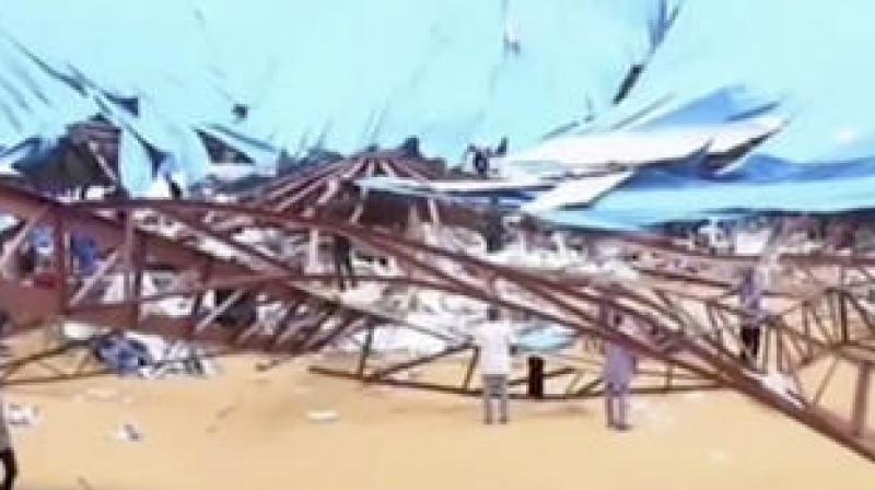 In this image taken from video people stand at the scene after the roof of The Reigners Bible Church International collapsed onto worshippers in Uyo, southern Nigeria. (Photo: AP)