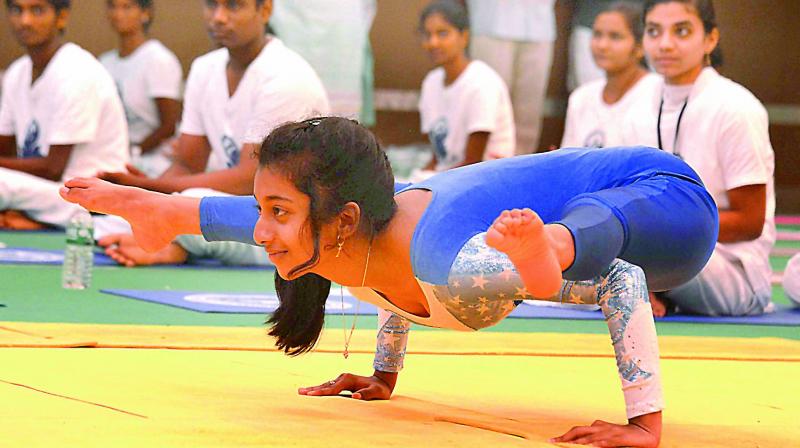 Ekambara Jyotsna from Nellore presents a yogic pose at A Convention Centre on the occasion of International Yoga Day celebrations in Vijayawada on Wednesday. (Photo: DC)