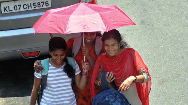 A group of girls take cover under an umbrella to escape from scorching heat in Kochi on Friday.  	- SUNOJ NINAN MATHEW.
