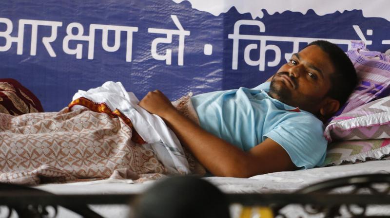 Patidar agitation leader Hardik Patel, who is on indefinite fast at his residence, rests in Ahmadabad, India. Hardik Patel has been on an indefinite fast for the last 11 days, demanding loan waivers for farmers and quotas for Patidars in government jobs and education under the Other Backward Class (OBC) category. (Photo: AP)