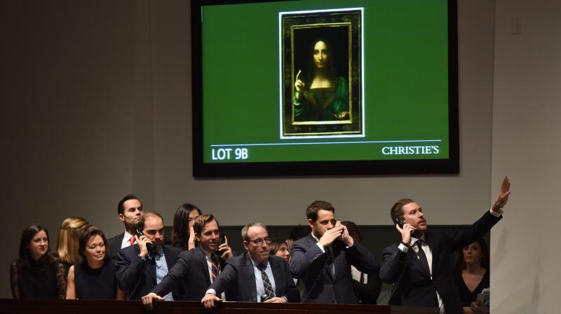 Christies employees take bids for Leonardo da Vincis \Salvator Mundi\ during the Post-War & Contemporary Art Evening Sale at Christies New York November 15, 2017. (Photo: AFP)