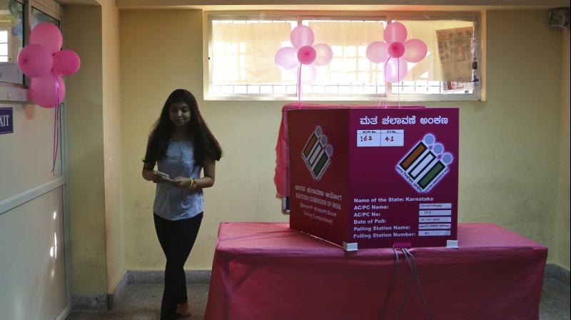 A woman leaves after casting her vote at a polling station decorated with pink balloons and managed by only women officials in Bangalore, India, Saturday, May 12, 2018. Indias southern state of Karnataka headed to the polls Saturday to elect 224 lawmakers. (Photo: AP)
