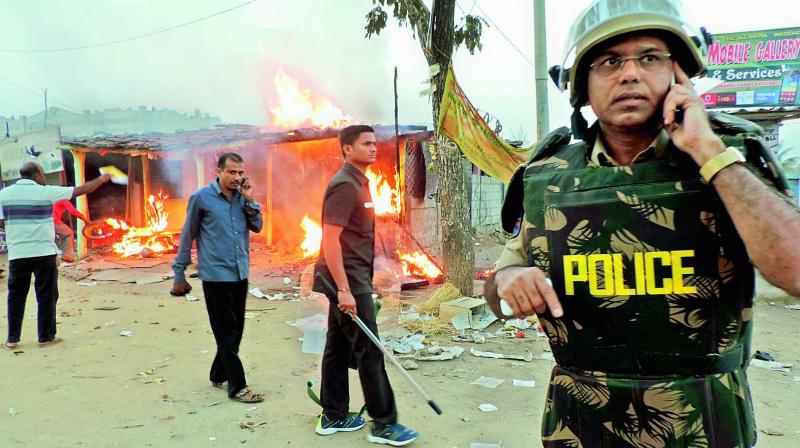 Superintendent of police P. Srinivas speaks on a cellphone at Husnabad where clashes broke out between Adivasi and Lambada groups. (Photo: DC)