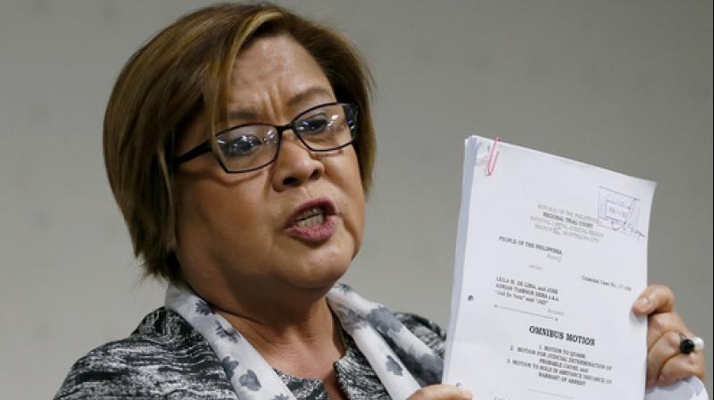 Philippine Sen. Leila de Lima shows documents on her petition to dismiss charges filed against her