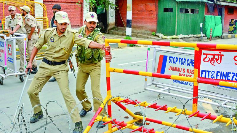 Police personnel block the road near the residences of former chief ministers Omar Abdullah and Mehbooba Mufti in Srinagar on Saturday. (Photo: AP)