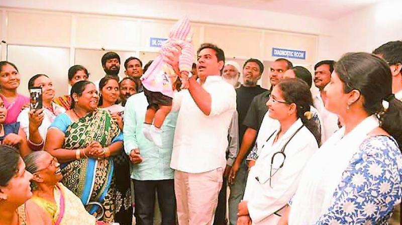 Minister K. T. Rama Rao lifts a baby as he interacts with patients, doctors and staff in Begumpet on Saturday.