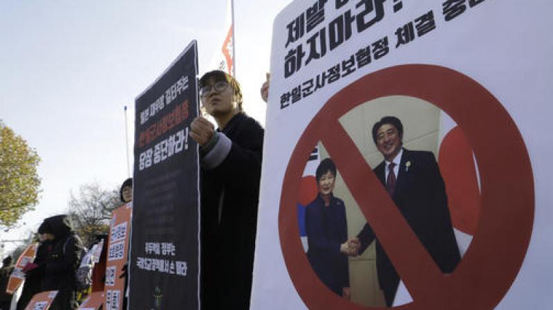 South Korean protesters with a picture of South Korean President Park Geun-hye, left, and Japanese Prime Minister Shinzo Abe, right, stage a rally to oppose the General Security of Military Information Agreement (GSOMIA) between South Korea and Japan, in front of the Defense Ministry in Seoul. (Photo: AP)